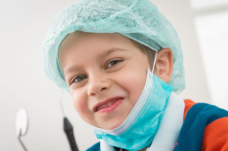 Junge mit Mundschutz und Haube