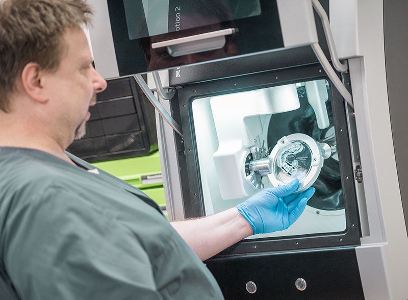 Unser Zahntechniker und CAD/CAM-Spezialist Dirk Martens begutachtet das Werkstück in der Computer-Fräse.